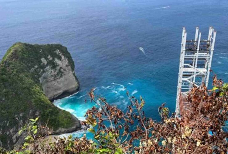Panorama Pantai Kelingking di Nusa Penida, Bali, terlihat dari atas tebing dengan laut biru jernih dan pasir putih.